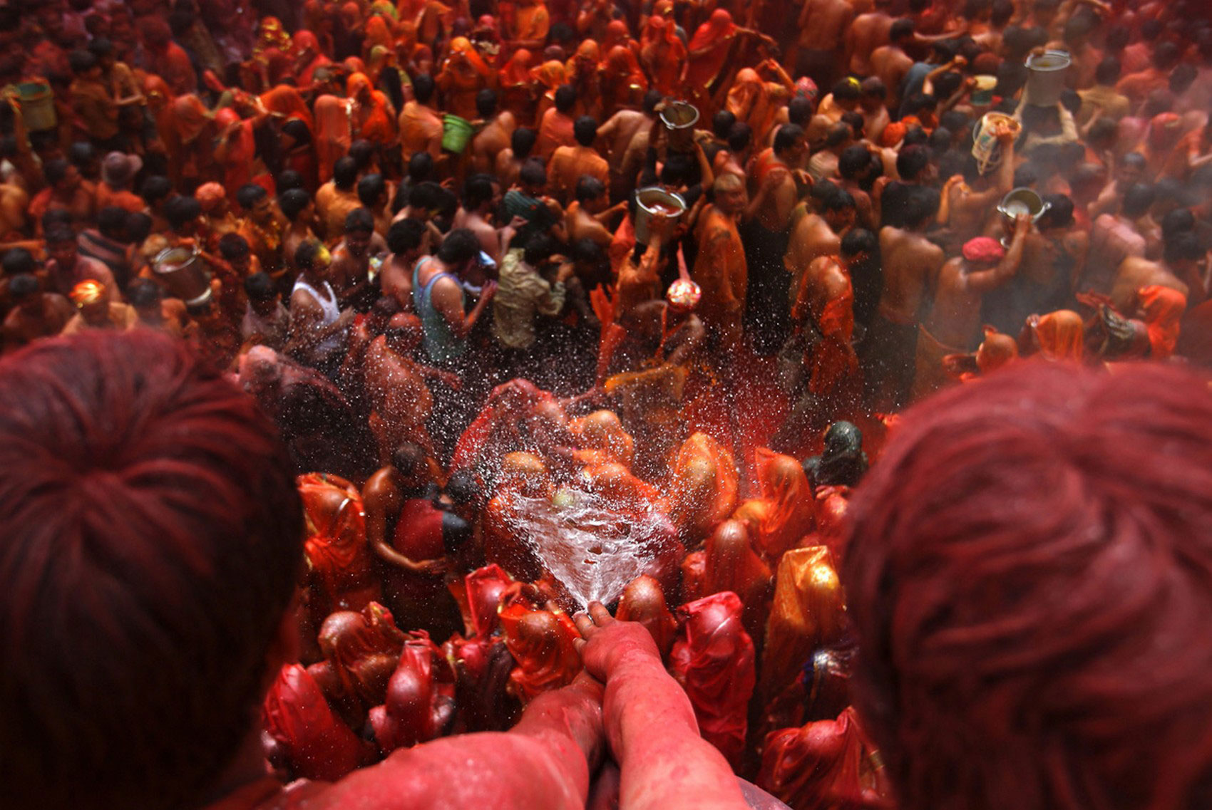 мужчины брызгают водой на толпу