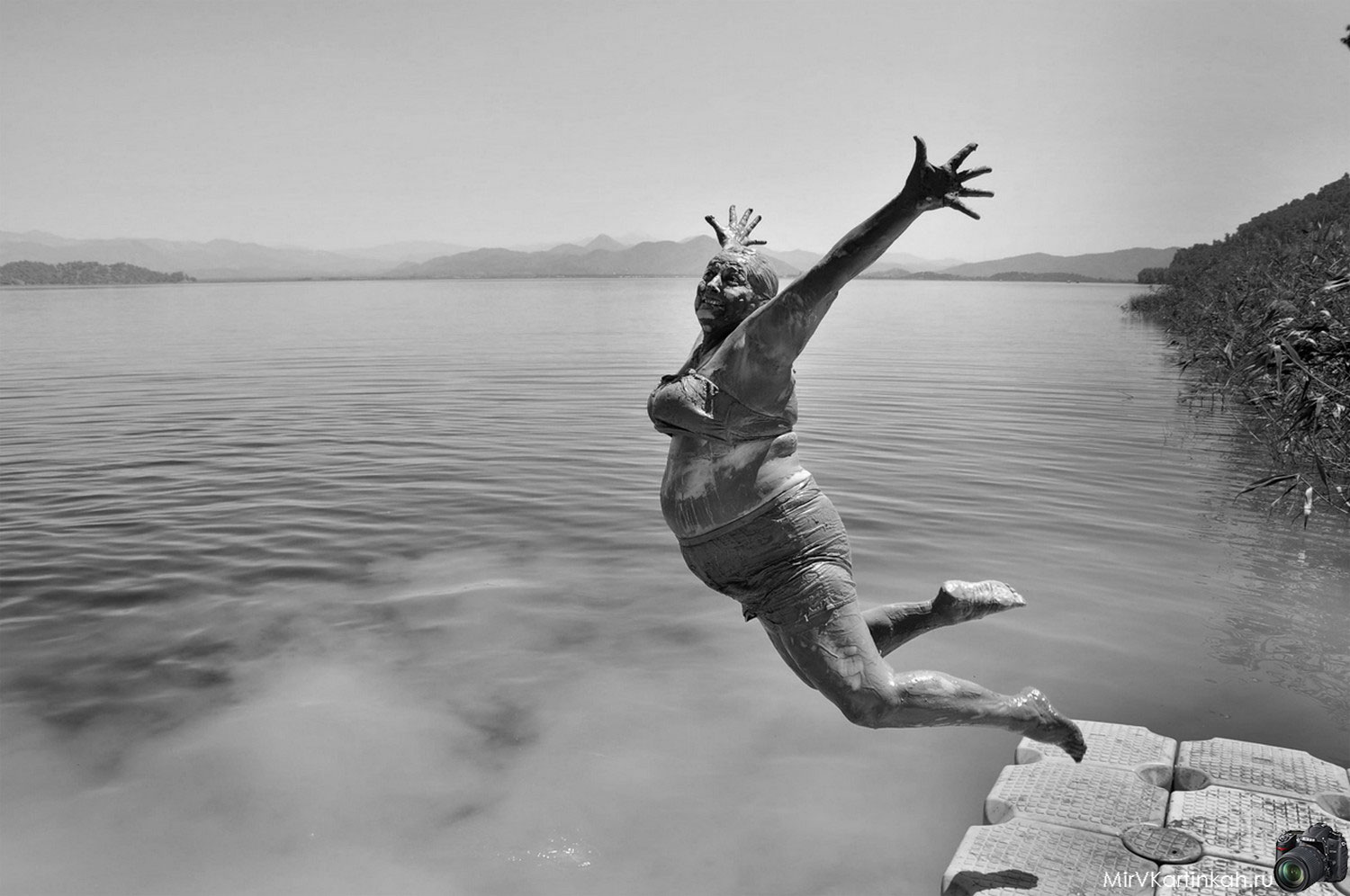 Женщина прыгает в озеро