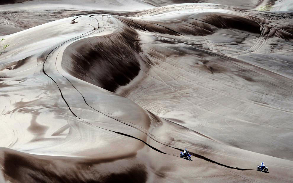 Два гонщика преодолевают дюны, фото с ралли Дакар