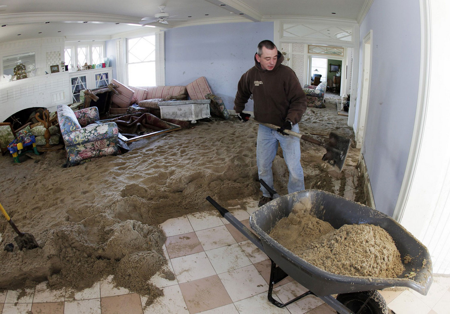 мужчина очищает свой дом от песка в США