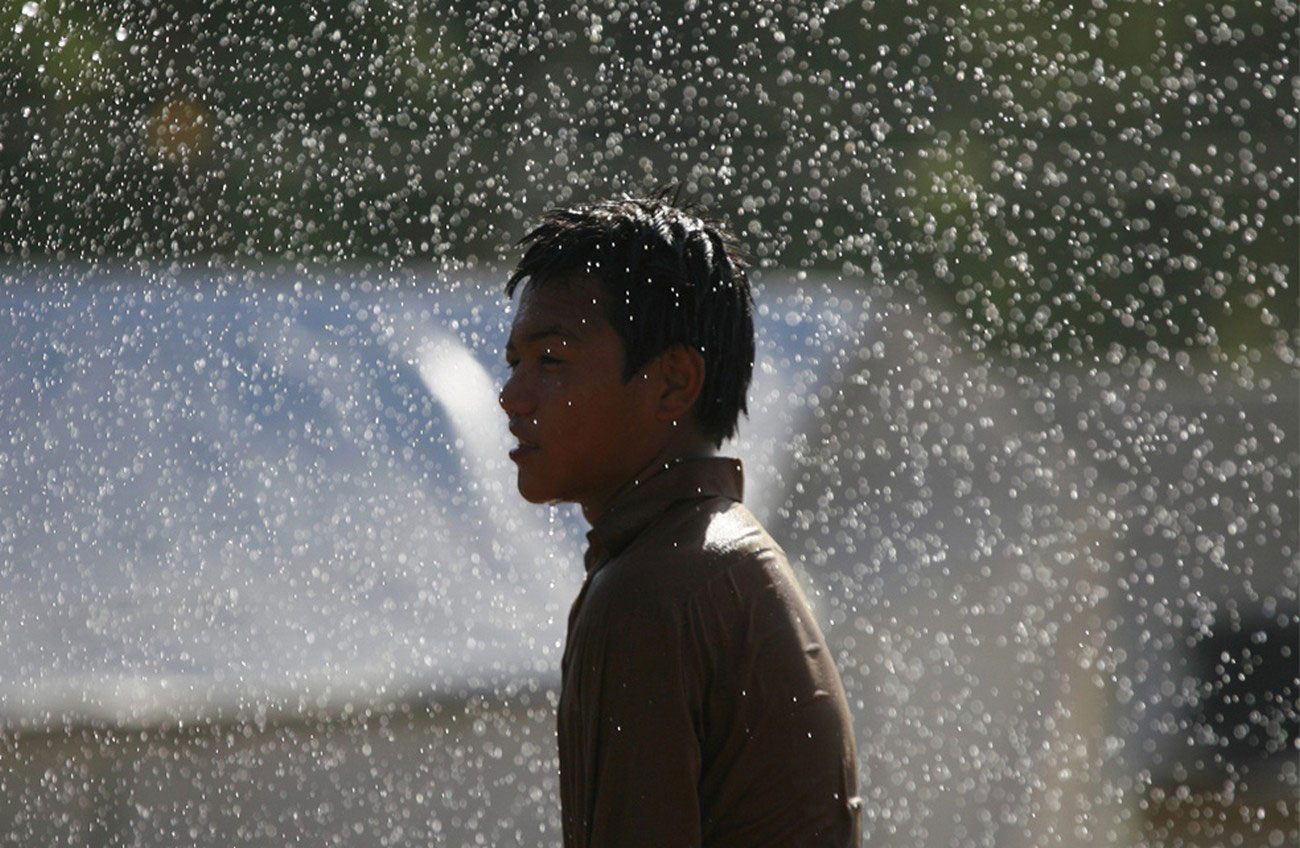 вынужденные переселенцы спасаются от жары при помощи воды